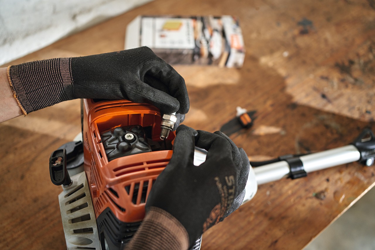 Close-up of how the spark plug is replaced on a STIHL gasoline hedge trimmer