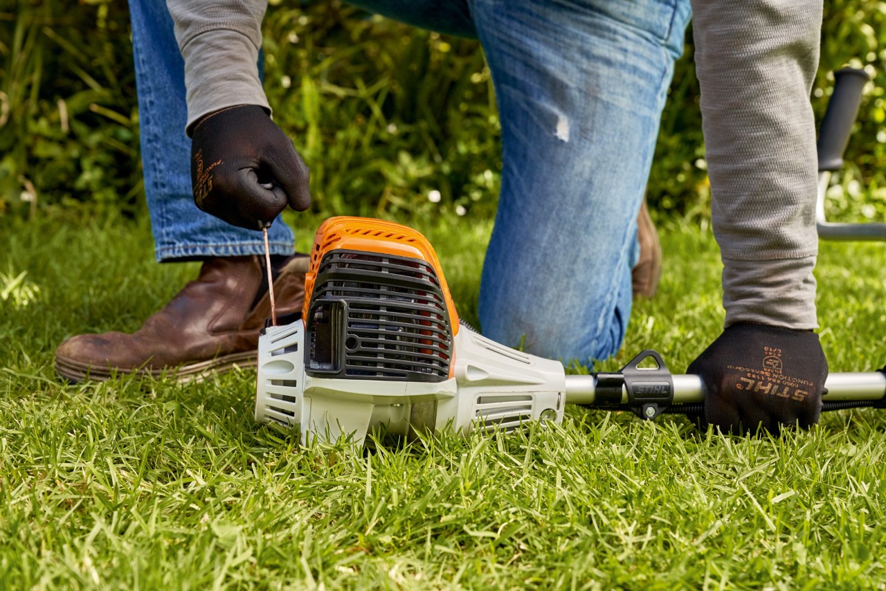 Mężczyzna pociąga linkę rozrusznika benzynowej kosy mechanicznej STIHL FS 91 
