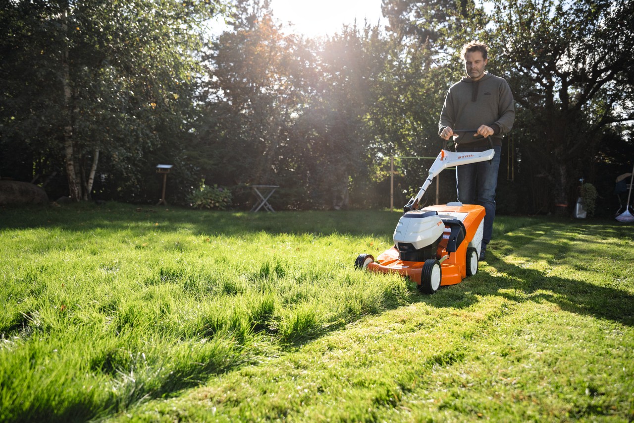 Mężczyzna kosi trawnik kosiarką akumulatorową STIHL RMA 448 VC